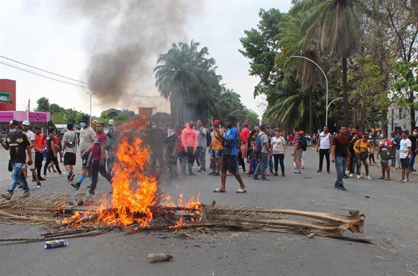 Migrantes centroamericanos y africanos queman palmeras durante unos enfrentamientos hoy, en Tapachula (México). EFE/ Juan Manuel Blanco
