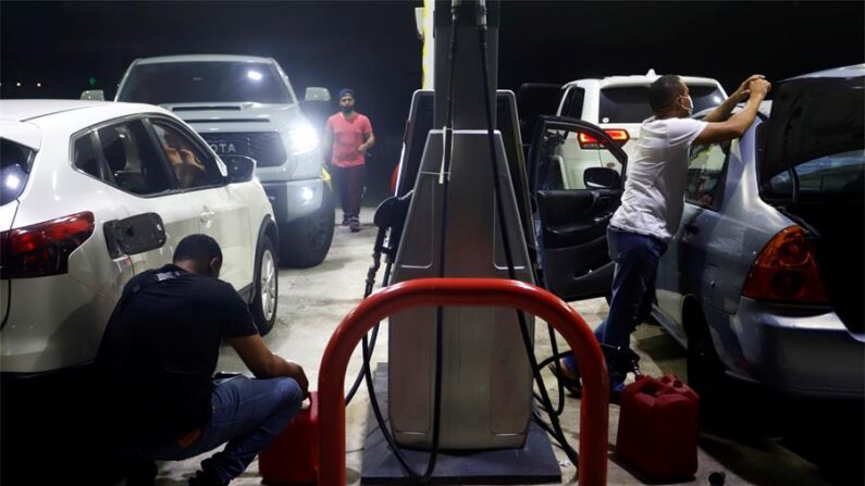 Personas llenan recipientes con gasolina en San Juan (Puerto Rico), en una fotografía de archivo. (EFE/Thais Llorca)