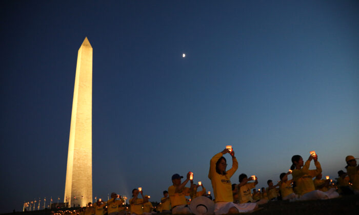 Los practicantes de Falun Gong participan en una vigilia con velas para recordar a las víctimas de la persecución durante 22 años en China en el Monumento a Washington,  el 16 de julio de 2021. (Samira Bouaou/The Epoch Times)