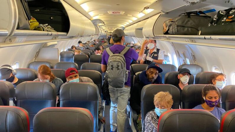 Pasajeros, casi todos con mascarillas, suben a un vuelo de American Airlines con destino a Charlotte, el 3 de mayo de 2020, en la ciudad de Nueva York.  (ELEONORE SENS/AFP vía Getty Images)