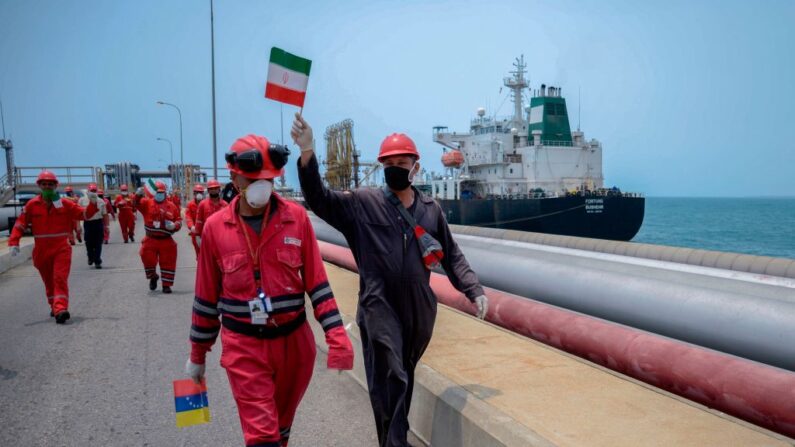 Un trabajador de la compañía petrolera estatal venezolana PDVSA agita una bandera iraní mientras el petrolero de bandera iraní Fortune atraca en la refinería El Palito en Puerto Cabello, en el estado norteño de Carabobo, Venezuela, el 25 de mayo de 2020. (AFP vía Getty Images)