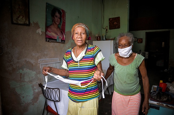 Las ancianas cubanas Olga (Der.) de 74 años, y Carmen More O’Farill de 85 años, permanecen en su casa en medio de la preocupación por la propagación del coronavirus COVID-19, en La Habana, el 2 de junio de 2020. (Foto de YAMIL LAGE/AFP a través de Getty Images)
