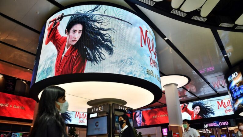 La gente pasa por delante de las pantallas de publicidad de la película Mulan de Disney en un cine dentro de un centro comercial en Bangkok el 8 de septiembre de 2020. (LILLIAN SUWANRUMPHA/AFP vía Getty Images)