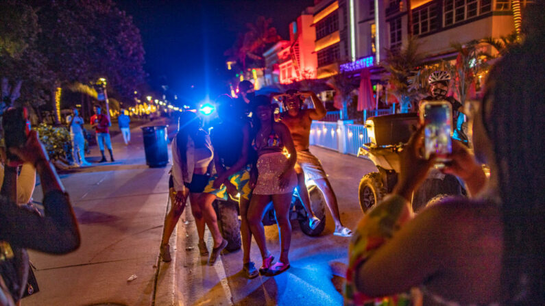 La policía de Miami Beach escolta a personas fuera de Ocean Drive, en Miami Beach, Florida, el 26 de marzo de 2021. (Saul Martinez/Getty Images)