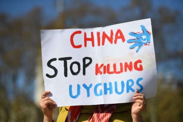 Un miembro de la comunidad uigur sostiene una pancarta, en Londres (Inglaterra), el 22 de abril de 2021. (Justin Tallis/AFP vía Getty Images)
