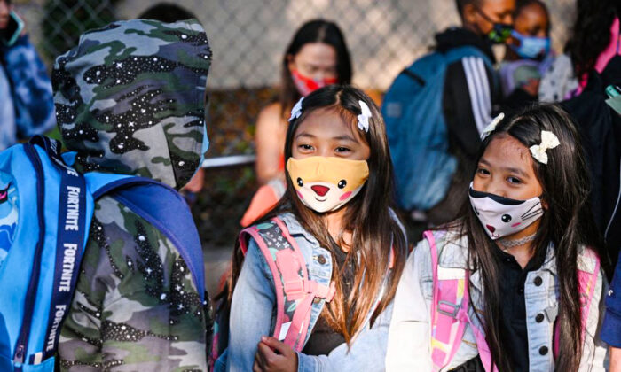 Estudiantes y padres llegan con mascarillas para el primer día del año escolar en la escuela primaria Grant en Los Ángeles, el 16 de agosto de 2021. (Robyn Beck/AFP vía Getty Images)