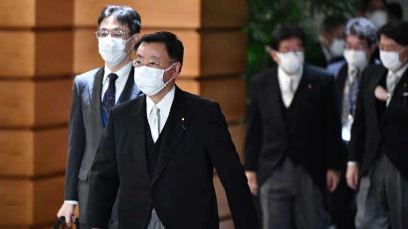El portavoz gubernamental de Japón, Hirokazu Matsuno (2i), junto con otros salen de la oficina del primer ministro mientras se dirigen a la ceremonia de certificación en el Palacio Imperial en Tokio (Japón) el 10 de noviembre de 2021. (Kazuhiro Nogi/AFP vía Getty Images)