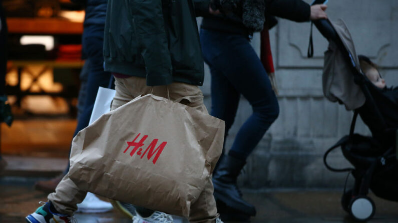 Compradores con una bolsa de H&M caminan por Regent Street el 27 de diciembre de 2021 en Londres, Inglaterra. (Hollie Adams/Getty Images)