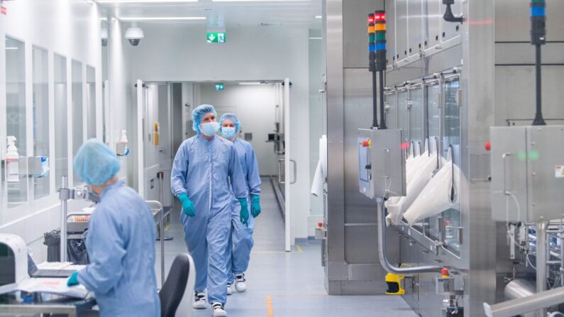 Empleados con equipo de protección trabajan en la sección de llenado aséptico de las instalaciones de la compañía farmacéutica AstraZeneca para medicamentos biológicos en Södertälje, al sur de Estocolmo, Suecia, el 8 de febrero de 2022. (Jonathan Nackstrand/AFP vía Getty Images)