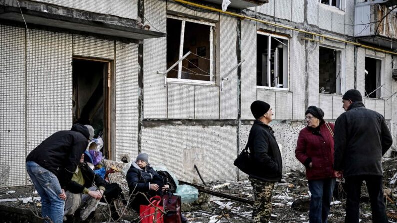 Gente fuera de un edificio destruido tras los bombardeos en la ciudad de Chuguiv, en el este de Ucrania, el 24 de febrero de 2022. (Aris Messinis/AFP vía Getty Images)