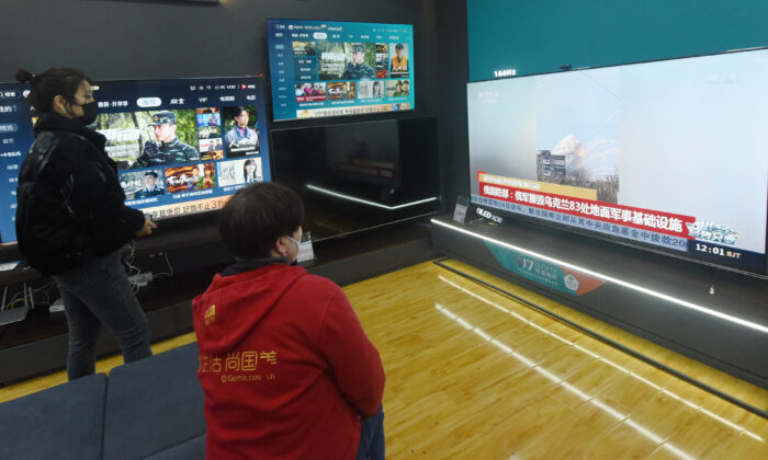 Los residentes ven una pantalla de televisión que muestra noticias sobre el conflicto entre Rusia y Ucrania en un centro comercial en Hangzhou, en la provincia oriental china de Zhejiang, el 25 de febrero de 2022. (STR/AFP a través de Getty Images)