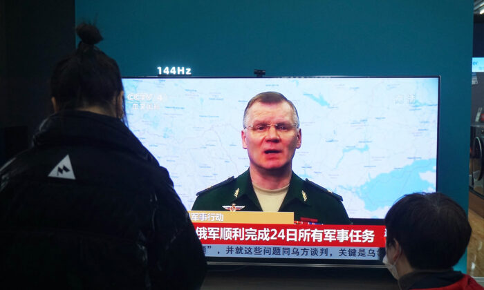 Los residentes ven una pantalla de televisión que muestra noticias sobre el conflicto entre Rusia y Ucrania en un centro comercial en Hangzhou, en la provincia oriental china de Zhejiang, el 25 de febrero de 2022. (STR/AFP a través de Getty Images)