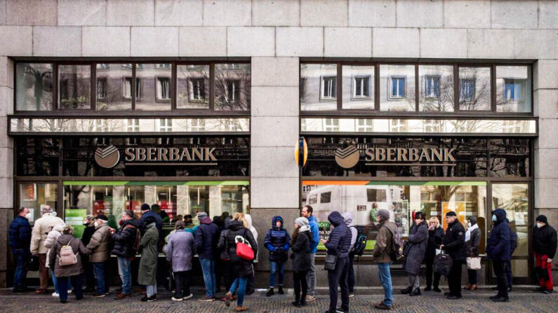 La gente hace fila frente a una sucursal del banco estatal ruso Sberbank para retirar sus ahorros y cerrar sus cuentas en Praga el 25 de febrero de 2022, antes de que Sberbank cerrara todas sus sucursales en la República Checa más tarde ese mismo día. (Michal Cizek/AFP vía Getty Images)