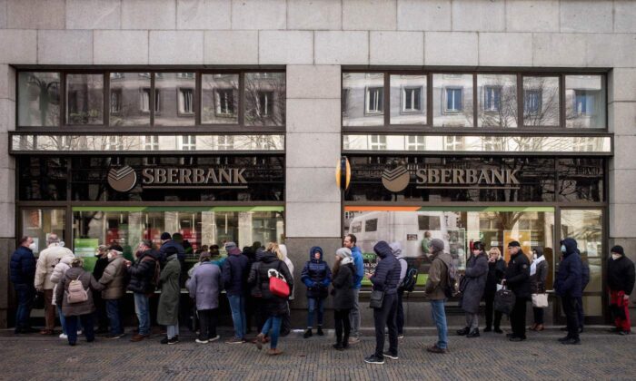 La gente hace fila frente a una sucursal del banco estatal ruso Sberbank para retirar sus ahorros y cerrar sus cuentas en Praga, el 25 de febrero de 2022, antes de que Sberbank cerrara todas sus sucursales en la República Checa ese mismo día. (Michal Cizek/AFP a través de Getty Images)