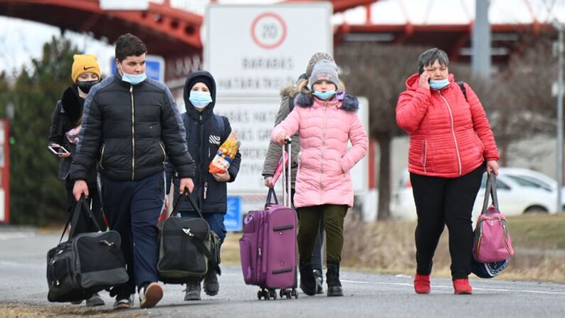Refugiados ucranianos cruzan la frontera a pie en Barabas, Hungría, el 28 de febrero de 2022. (ATTILA KISBENEDEK/AFP vía Getty Images)