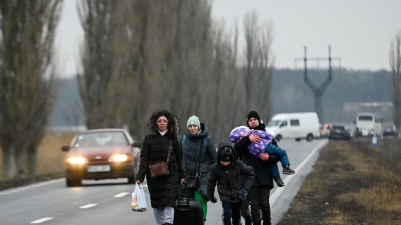 Refugiados de Ucrania caminan por una carretera tras cruzar el puesto de control de la frontera entre Moldavia y Ucrania, cerca de la ciudad de Palanca, el 1 de marzo de 2022. (NIKOLAY DOYCHINOV/AFP vía Getty Images)
