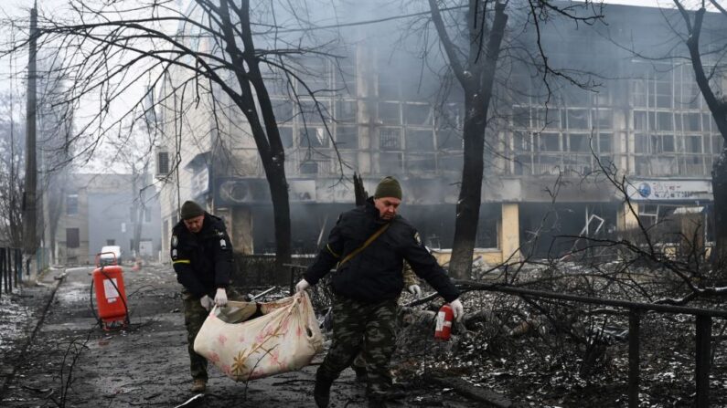 Agentes de policía retiran el cuerpo de un transeúnte muerto en el ataque aéreo de ayer que golpeó la principal torre de televisión de Kiev en Kiev el 2 de marzo de 2022. (ARIS MESSINIS/AFP vía Getty Images)