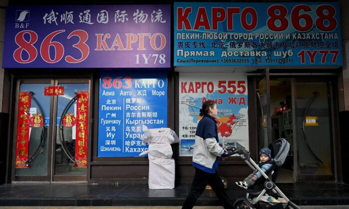 La gente pasa frente a las tiendas con letreros en escritura cirílica en un centro comercial conocido como el Mercado de Rusia en Beijing, el 3 de marzo de 2022. (Noel Celis/AFP a través de Getty Images)