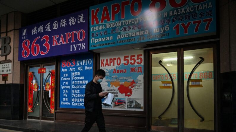 Un hombre pasa por delante de una tienda que anuncia envíos de carga a Rusia y otros países, en una calle de Beijing el 4 de marzo de 2022. (Hector Retamal/AFP vía Getty Images)