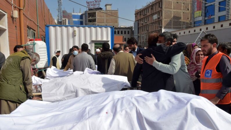 Personas se reúnen junto a los cuerpos de las víctimas en el exterior de un hospital tras la explosión de una bomba en una mezquita en Peshawar el 4 de marzo de 2022. (ABDUL MAJEED/AFP vía Getty Images)