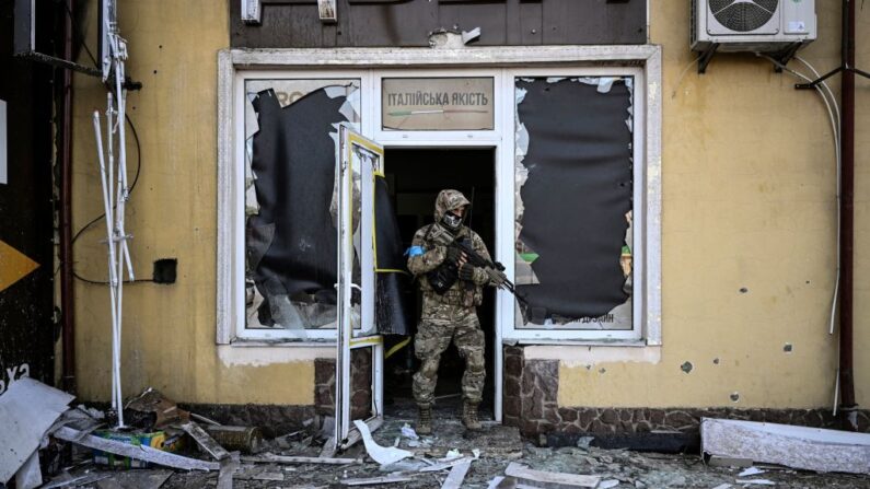 Un militar ucraniano sale de un edificio dañado después de un bombardeo en Kiev, el 12 de marzo de 2022. (ARIS MESSINIS/AFP vía Getty Images)