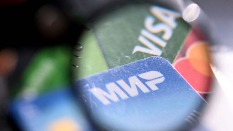 Una foto tomada el 14 de marzo de 2022 muestra los logotipos de los sistemas de pago Visa, Mastercard y Russian Mir en tarjetas bancarias en Moscú. (AFP vía Getty Images)