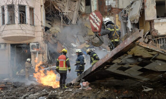Los bomberos trabajan para despejar los escombros y extinguir un incendio en un edificio seriamente dañado por un cohete ruso, en la segunda ciudad de Ucrania, Jarkiv, el 14 de marzo de 2022. (Sergey Bobok/AFP vía Getty Images)