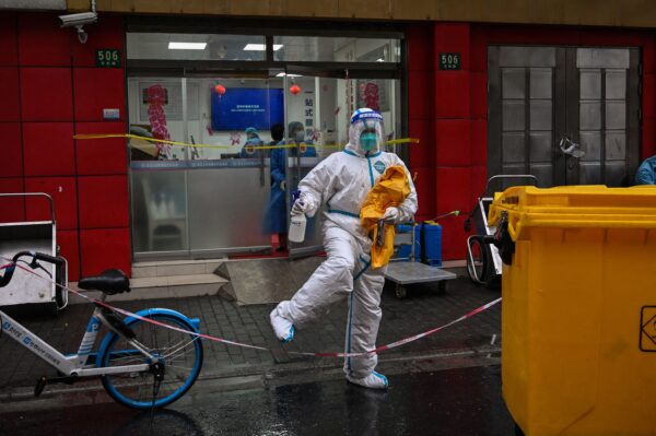 Un trabajador de la salud con equipo de protección cruza una línea frente a un hospital en un barrio cerrado, en el distrito Huangpu de Shanghái, China, el 21 de marzo de 2022. (Hector Retamal/AFP vía Getty Images)
