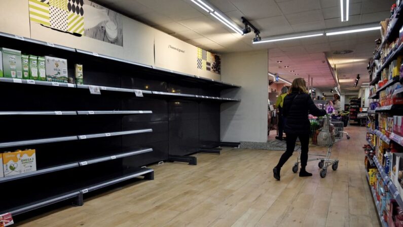 Una cliente pasa frente a los estantes vacíos de un supermercado en Madrid (España) el 23 de marzo de 2022. (Oscar Del Pozo/AFP vía Getty Images)