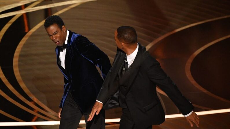 Will Smith (de) golpea a Chris Rock mientras éste habla en el escenario durante la 94ª edición de los Premios de la Academia en Hollywood, Los Ángeles, California, el 27 de marzo de 2022. 
 (Robyn Beck / AFP via Getty Images)
