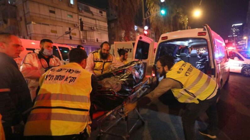 Miembros de los servicios de emergencia de Israel evacuan un cuerpo del lugar de un ataque con armas de fuego el 29 de marzo de 2022 en Bnei Brak (Israel). (Gil Cohen-Magen/AFP vía Getty Images)