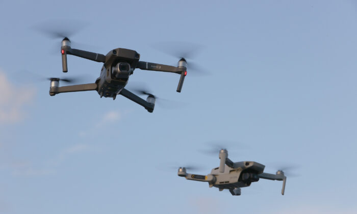 Un DJI Mavic 2 Pro y un DJi Mavic Mini del fabricante chino de drones vuelan uno cerca del otro en Miami, Florida, el 15 de diciembre de 2021. (Joe Raedle/Getty Images)