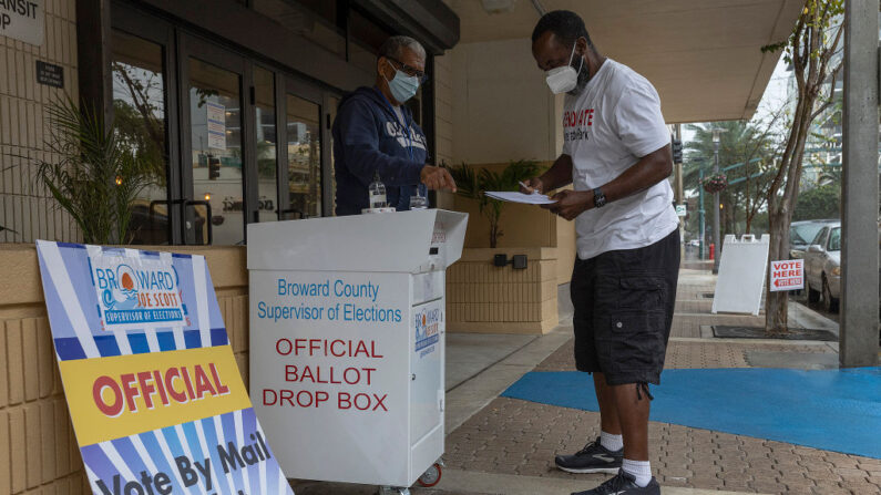 Wilbur Harbin se prepara para depositar su papeleta en una urna de voto por correo durante las elecciones del distrito 20 del Congreso el 11 de enero de 2022 en Ft. Lauderdale, Florida. (Joe Raedle/Getty Images)