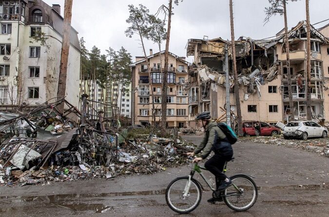 Mientras Rusia continúa su asalto a las principales ciudades de Ucrania, incluida la capital, Kiev, un hombre pasa con su bicicleta por delante de edificios destruidos en Irpin, Ucrania, el 3 de marzo de 2022. (Chris McGrath/Getty Images)