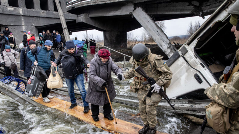 Los residentes de Irpin huyen de los intensos combates a través de un puente destruido cuando las fuerzas rusas entraron en la ciudad el 07 de marzo de 2022 en Irpin, Ucrania. (Chris McGrath/Getty Images)