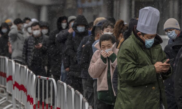 La gente espera en la fila para dar una muestra en la prueba por COVID-19 de ácido nucleico en un sitio de prueba en Beijing, China, el 17 de marzo de 2022. (Kevin Frayer/Getty Images)