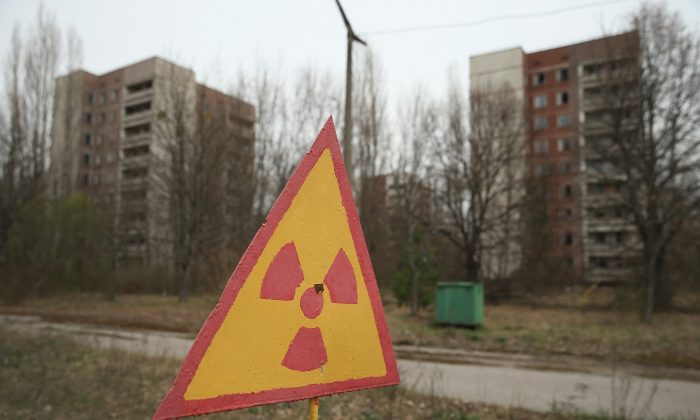Un cartel advierte sobre la contaminación por radiación cerca de antiguos edificios de apartamentos en Pripyat, cerca de Chernóbil, Ucrania, el 9 de abril de 2016. (Sean Gallup/Getty Images)