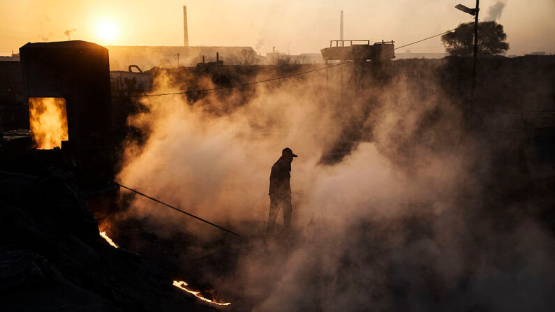 Un trabajador chino camina sobre el vapor junto a un horno y un pozo de enfriamiento en una fábrica de acero no autorizada, el 4 de noviembre de 2016, en Mongolia Interior, China. (Kevin Frayer/Getty Images)