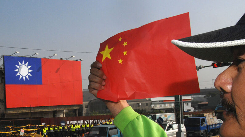 Un manifestante antichino sostiene la bandera nacional de China durante una manifestación frente al hotel Windsor, el 22 de diciembre de 2009. (PATRICK LIN/AFP via Getty Images)