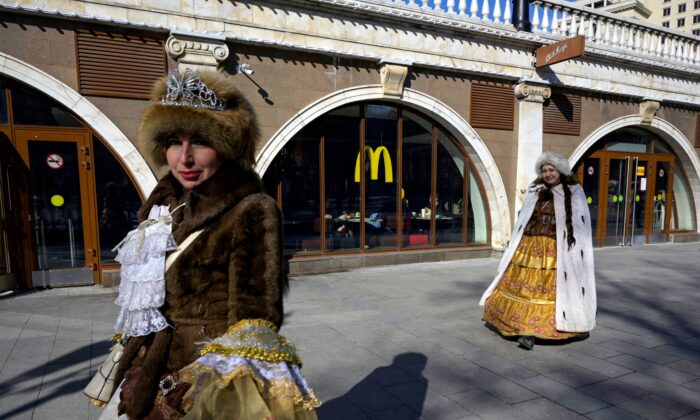 Mujeres caminan frente a un restaurante McDonald's en el centro de Moscú, el 9 de marzo de 2022. (AFP a través de Getty Images)