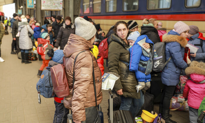 Refugiados ucranianos se preparan para abordar un tren a Polonia en la estación de tren de Lviv, Ucrania, el 18 de marzo de 2022. (Charlotte Cuthbertson/The Epoch Times)