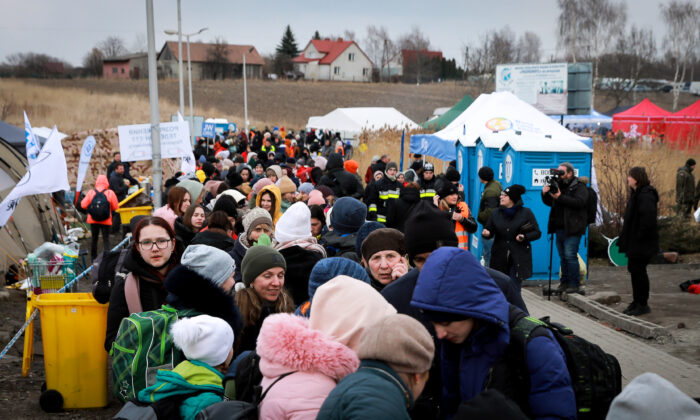 Refugiados ucranianos esperan un autobús que se dirige hacia el oeste tras llegar a Polonia a través del paso fronterizo de Medyka el 10 de marzo de 2022. (Charlotte Cuthbertson/The Epoch Times)