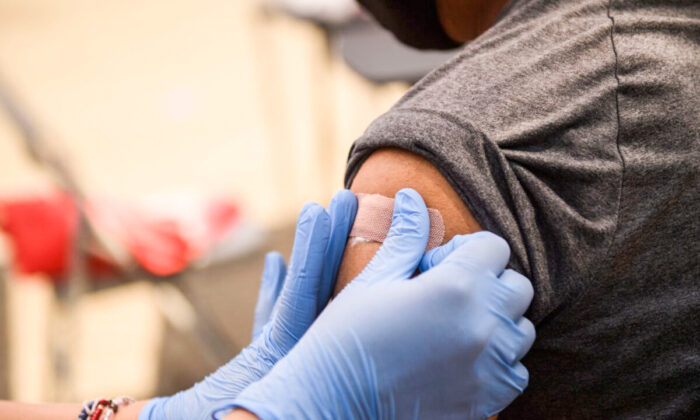Una persona recibe un parche después de su primera dosis de la vacuna contra COVID-19 de Pfizer en una clínica de Los Ángeles, California, el 7 de agosto de 2021. (Patrick T. Fallon/AFP vía Getty Images)