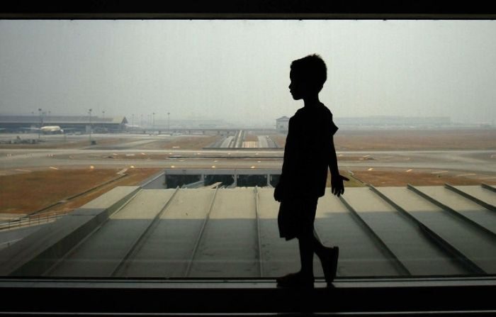 Un niño espera la llegada de sus familiares en el aeropuerto internacional de Kuala Lumpur. (Rahman Roslan/Getty Images)