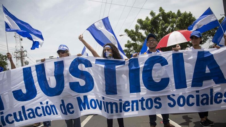 Fotografía de archivo del 21 de julio de 2018 que muestra a varios manifestantes que sostienen una pancarta en demanda de justicia durante una protesta en contra del gobierno de Daniel Ortega, en Managua (Nicaragua). EFE/ Jorge Torres