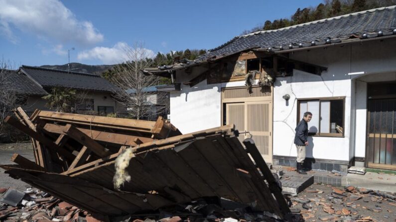 El fabricante de sushi Akio Hanzawa camina frente a su restaurante dañado en Shiroishi, prefectura de Miyagi, el 17 de marzo de 2022, después de que un terremoto de 7,4 grados sacudiera el este de Japón la noche anterior. (CHARLY TRIBALLEAU/AFP vía Getty Images)