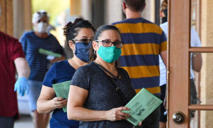 La gente espera en la fila para dejar los votos por correo en un lugar de votación anticipada en Phoenix, Arizona, el 16 de octubre de 2020. (Robyn Beck/AFP vía Getty Images)
