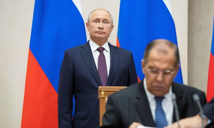 El ministro de Relaciones Exteriores de Rusia, Sergei Lavrov (D), firma documentos mientras el presidente ruso Vladimir Putin asiste a una ceremonia de firma en Sochi, Rusia, el 17 de octubre de 2018. (Pavel Golovkin/Pool/AFP vía Getty Images)

