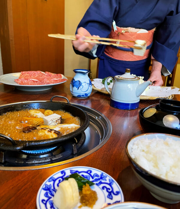 Los hábiles nakai, camareros profesionales, colocan los ingredientes en la salsa a fuego lento para que se cocinen. (Melissa Uchiyama)