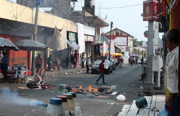 Migrantes de origen haitiano encienden una barricada en un mercado de Tapachula, en el estado de Chiapas (México), el 20 de abril de 2022. EFE/Juan Manuel Blanco
